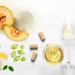Letnia kompozycja z melonem, cytryną, agrestem i kieliszkiem orzeźwiającego **vinho verde**.