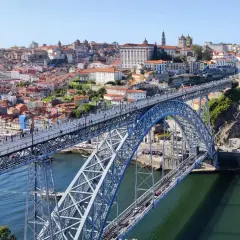 Most Louisa Martinez wino, widok na most Ponte de Dom Luís I w Porto, Portugalia, z zabytkową zabudową w tle.