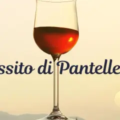 Kieliszek z bursztynowym winem, idealnym na zachód słońca. Napis "Passito di Pantelleria" dodaje mu elegancji.