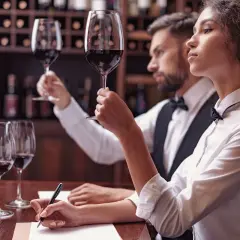 Para degustacji wina: kobieta i mężczyzna oceniają smak wina, notując wrażenia.