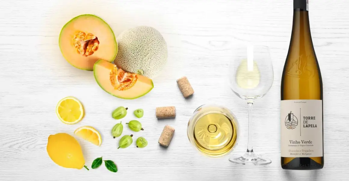 Letnia kompozycja z melonem, cytryną, agrestem i kieliszkiem orzeźwiającego **vinho verde**.